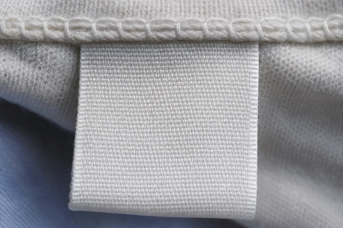 Macro view of a blank woven label stitched into a garment seam