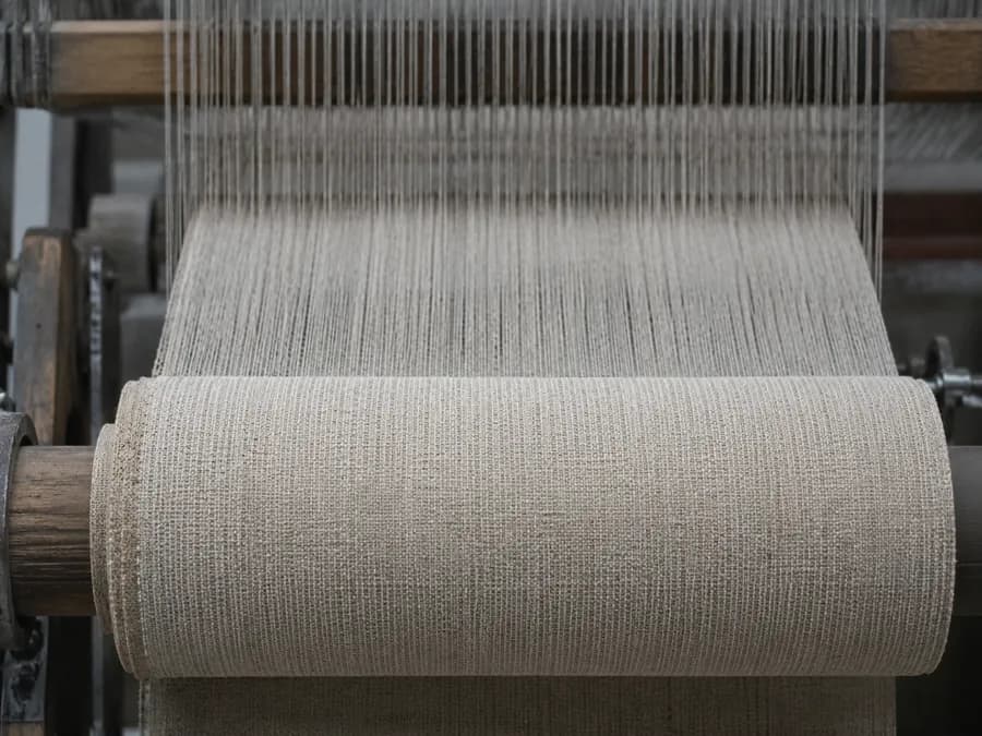 Greige woven cloth rolling onto a loom beam