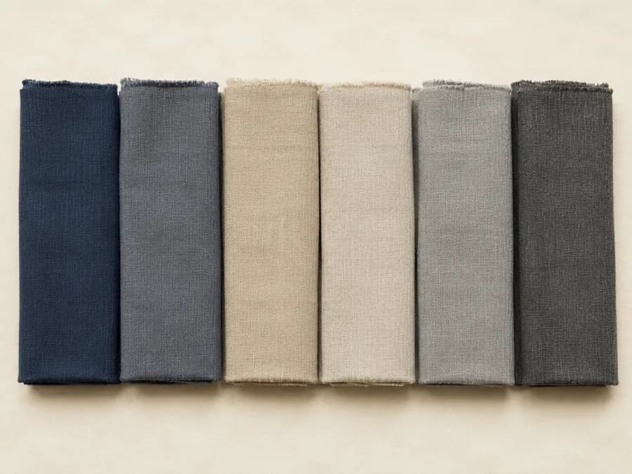 Six folded fabric swatches in muted dyed tones
